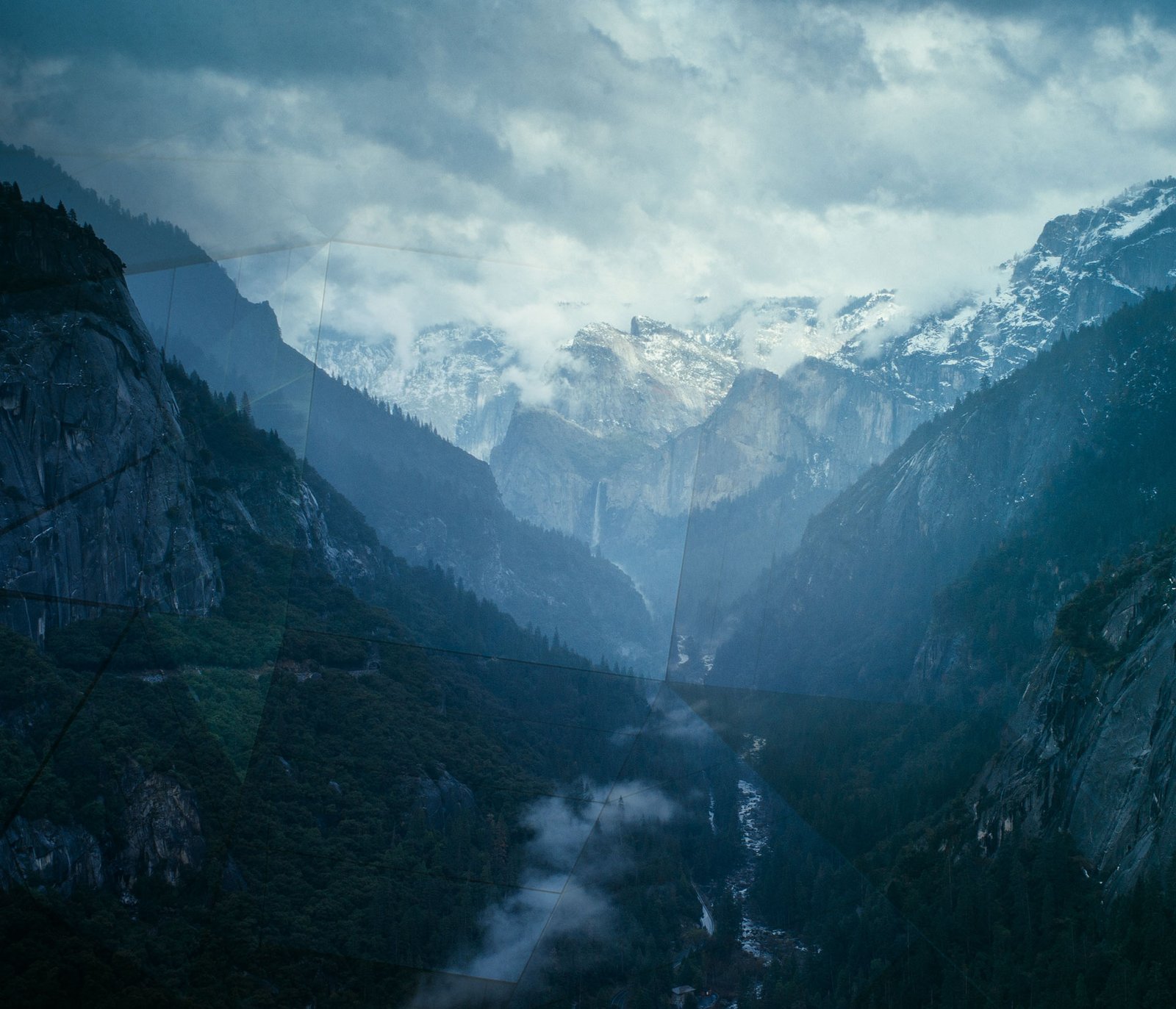 Blue image of a valley and a river.